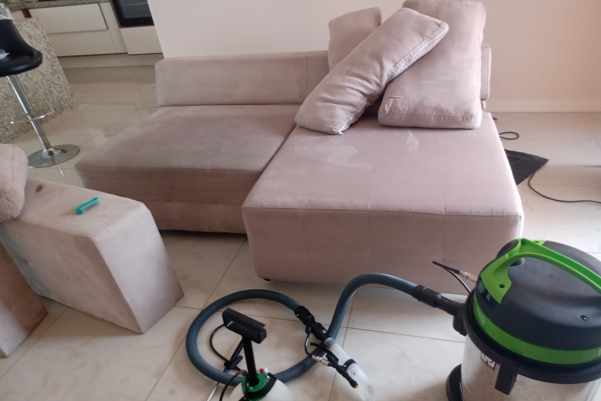 Sofá com maquinas de limpeza próximas a ele